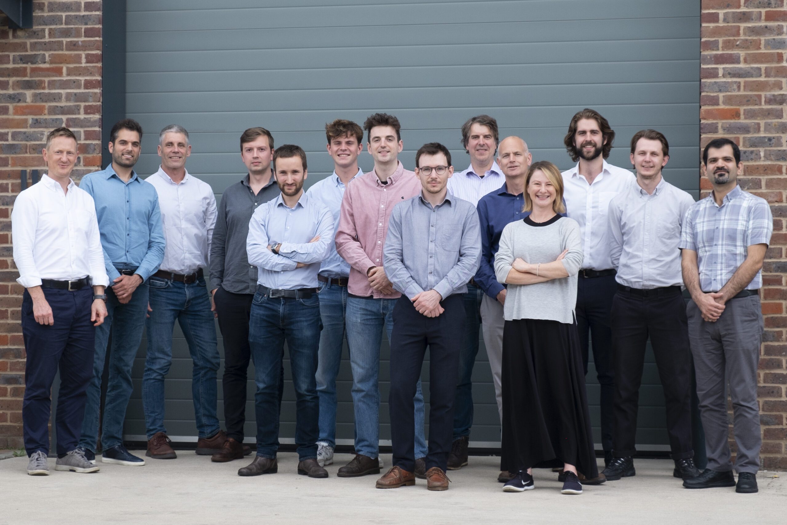 The Levistor team dressed in smart-casual attire, photographed as a group in front of their factory building.