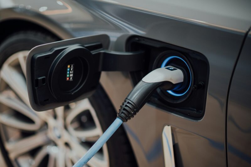 Close-up photo of a charger connected to the charging port of an electric car.